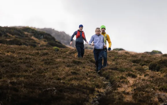 Group running down hill with waterproof gear on   Lake District ELSEY WHYMAN DAVIS CREDIT 