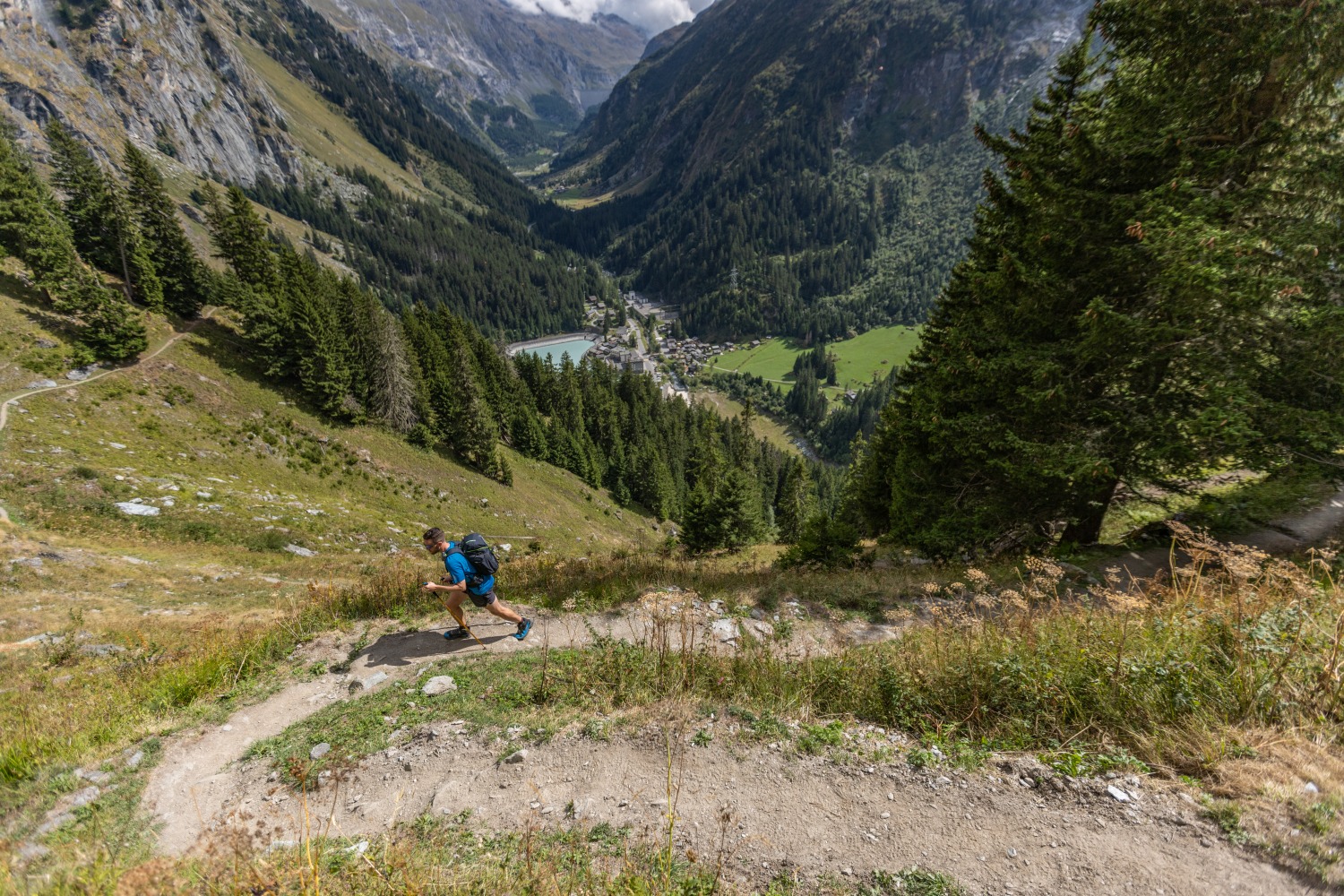 Man running up winding path amongst green mountains - Verbier 