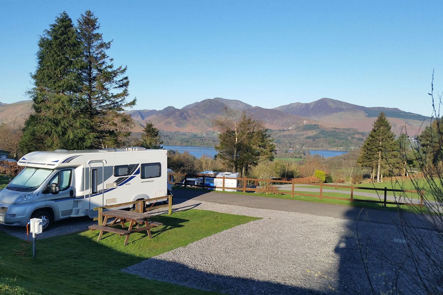 Camper van parked up with lake and mountains in background - Castlerigg Hall Caravan Site, Lake District