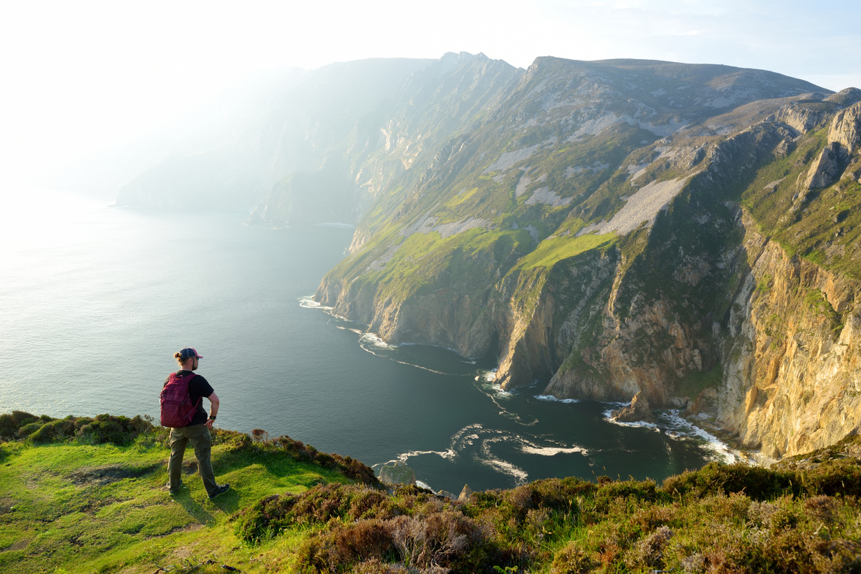 hiker on top of a cliff in ireland