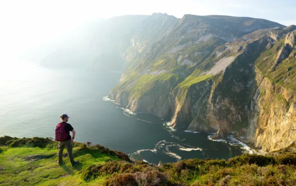 hiker on top of a cliff in ireland