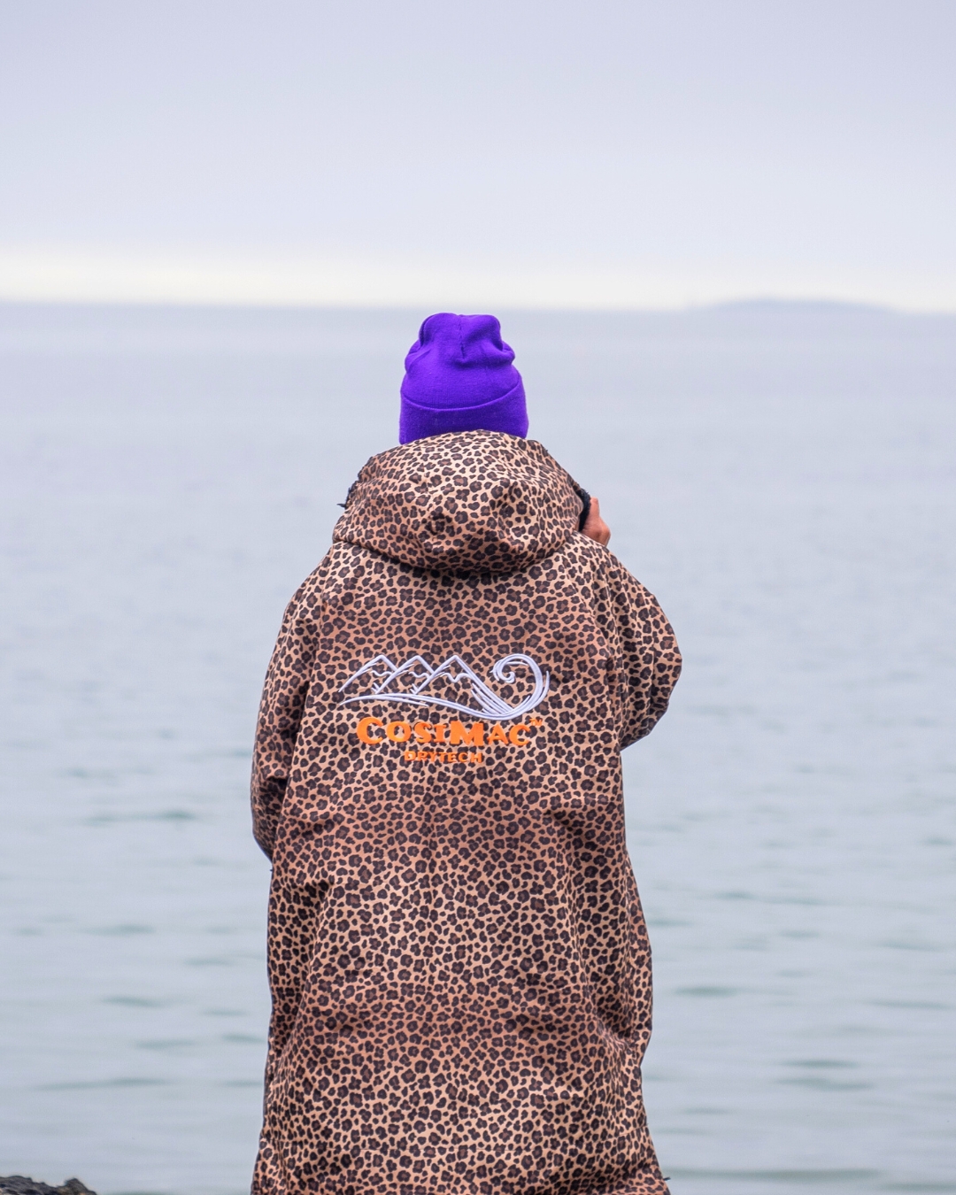 woman wearing changing robe looking out to sea