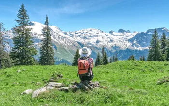 woman sitting on a rock with mountains behind