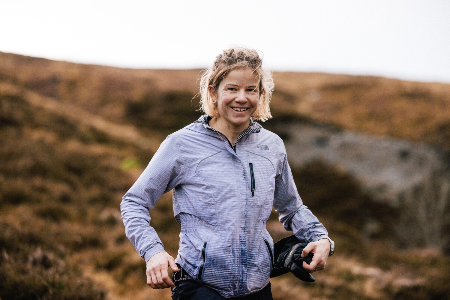 Woman smiling with purple North Face jacket on - Lake District