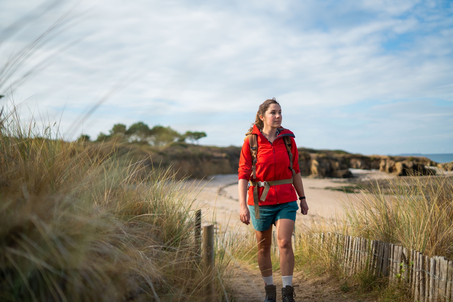 Woman walking along sandy footpath on beach - Brittany, France